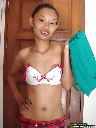 Fragile Thai girl takes her panties off and stays naked in doorway